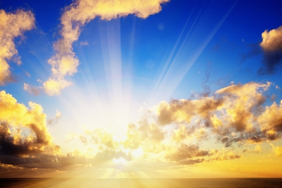 The sun breaks through clouds as it rises - or sets - on the horizon, creating dramatic lens flare. As the saying goes, every cloud has a silver lining.